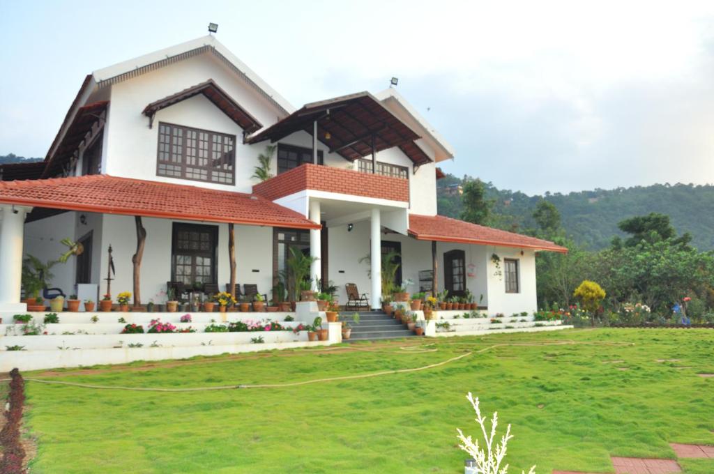 a house with a lawn in front of it at Abiyal Mountain Stay in Madikeri