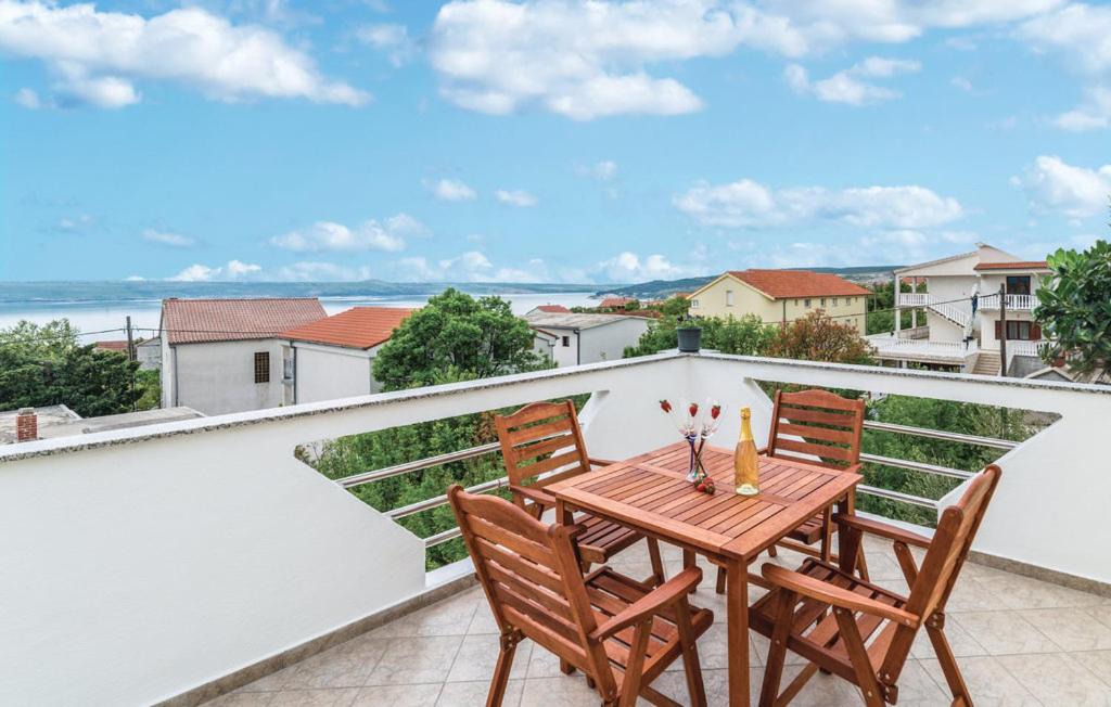 una mesa y sillas en un balcón con vistas al océano en Apartments Magdalena, en Maslenica