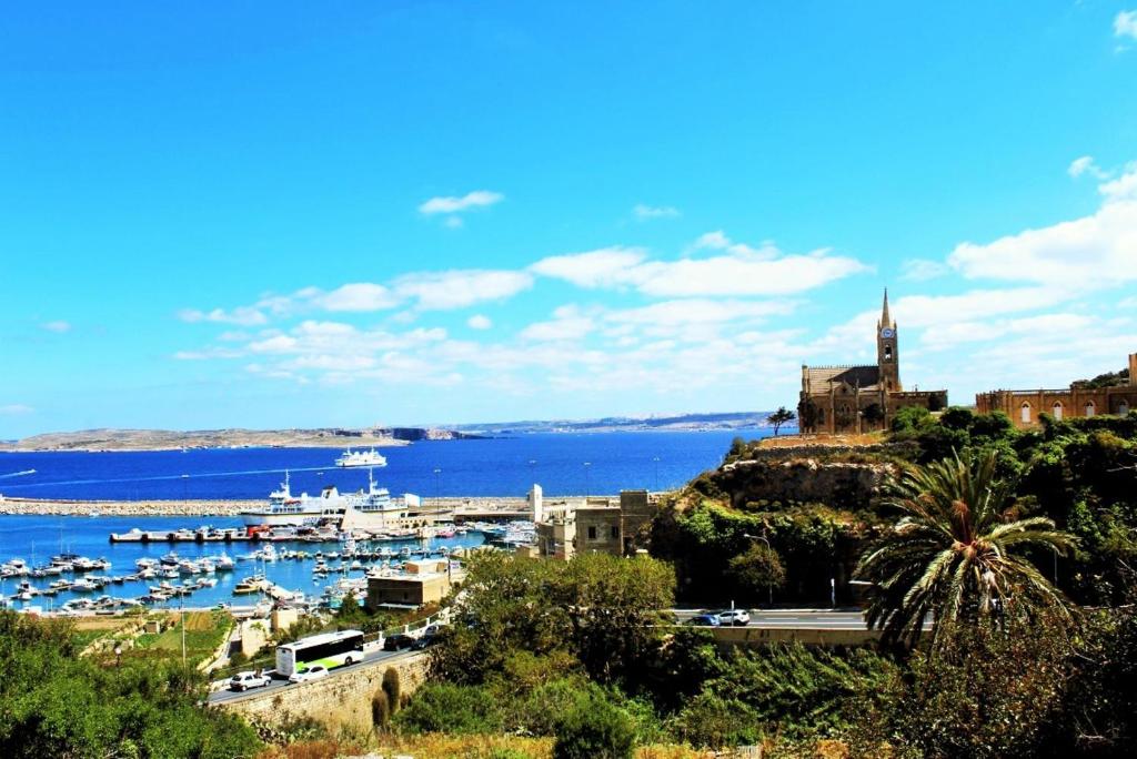 een uitzicht op een haven met boten in het water bij Seaview Luxury Penthouse in Għajnsielem