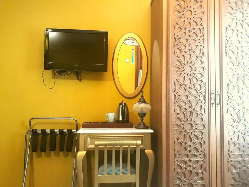 a room with a television and a table with a mirror at Merial Hotel Sultanahmet in Istanbul