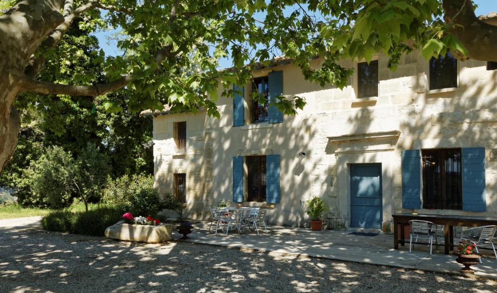 un bâtiment blanc avec des tables et des chaises devant lui dans l'établissement Le Mas d'Isnard, à Arles