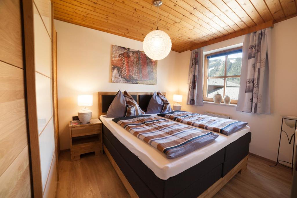 ein Schlafzimmer mit einem großen Bett und einer Holzdecke in der Unterkunft Appartement Philips in Flachau