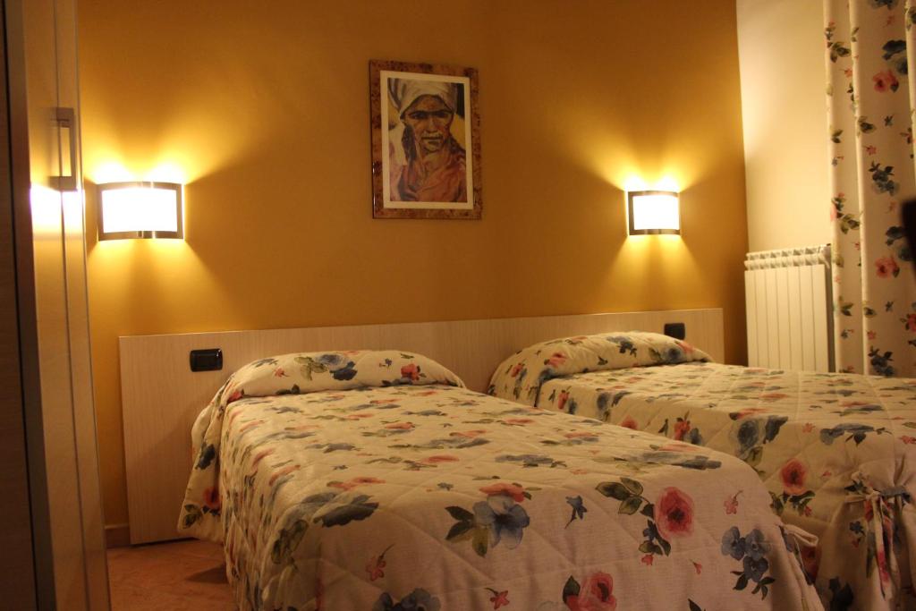 Habitación de hotel con 2 camas y una foto en la pared en B&B Le Quattro Fontane, en Gravina in Puglia