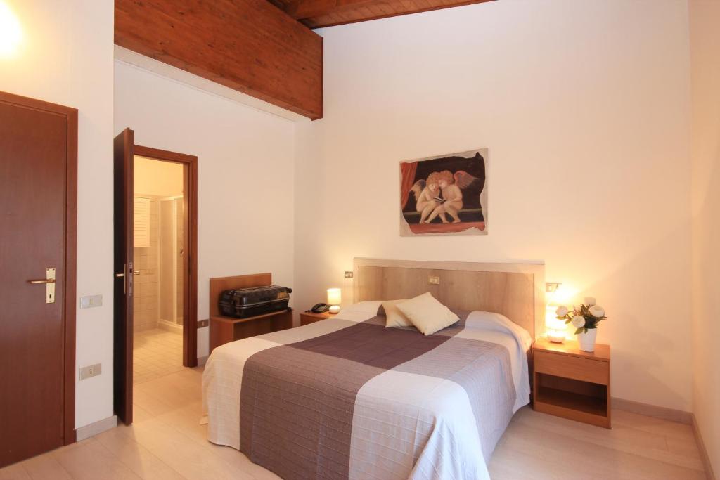 a bedroom with a bed and a picture on the wall at Hotel Colomber in Gardone Riviera