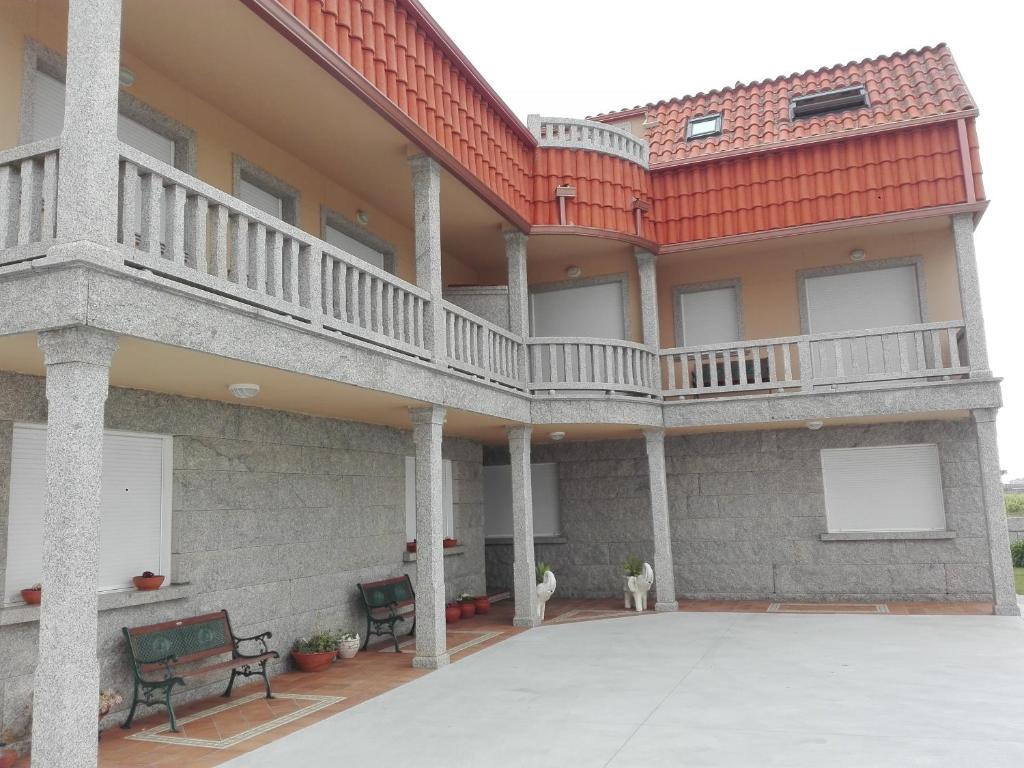 einen Außenblick auf ein Gebäude mit einem Balkon in der Unterkunft Apartamentos Esther in Sanxenxo