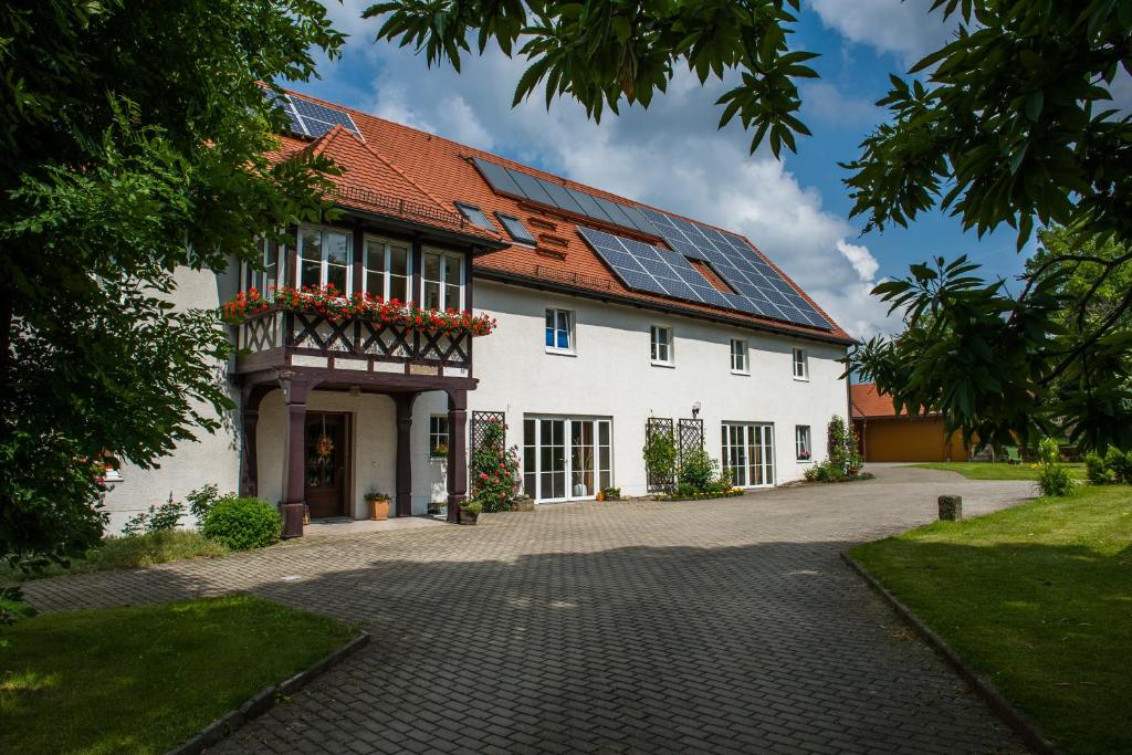 Struppen的住宿－Landhaus Angelika，一座大型白色房子,上面装有太阳能电池板