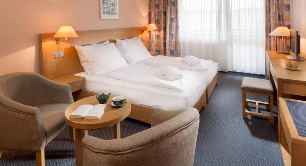 フリンブルクにあるApartman Lipnoのベッド、テーブル、椅子が備わるホテルルームです。