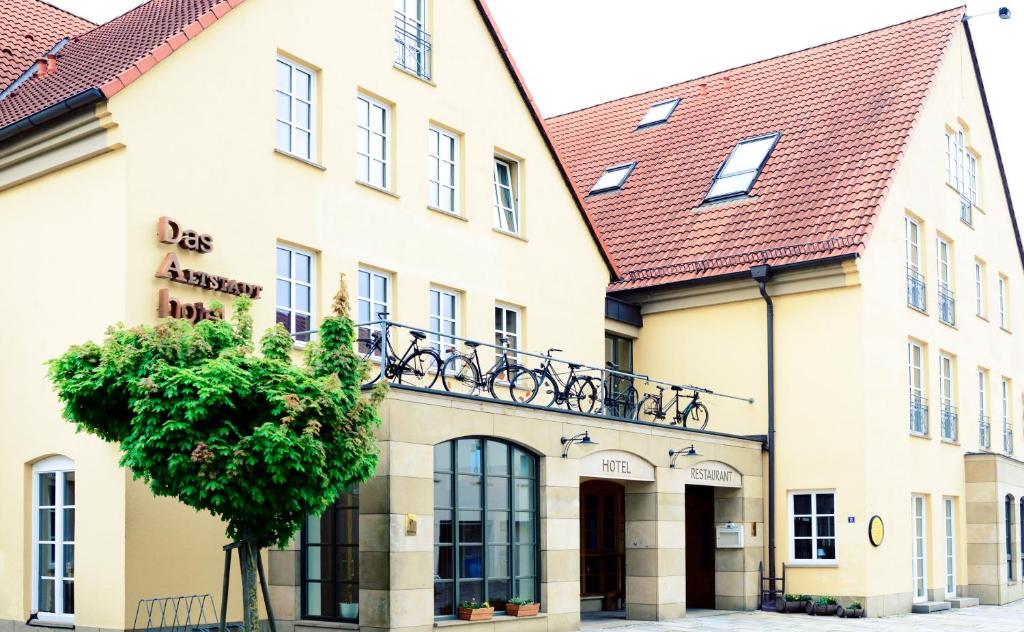 un bâtiment avec un arbre en face dans l'établissement Altstadthotel Haßfurt GbR, à Hassfurt