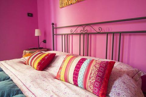 ピエトラ・リーグレにあるGhiro Ghiottoのピンクの壁のベッドルーム1室、ベッド1台(枕付)