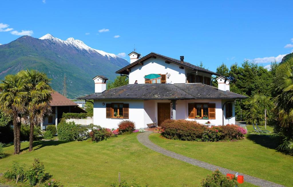 una casa blanca con una montaña en el fondo en Villa Palma, en Colico