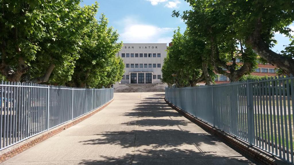 una valla y árboles frente a un edificio en Centro San Viator, en Valladolid