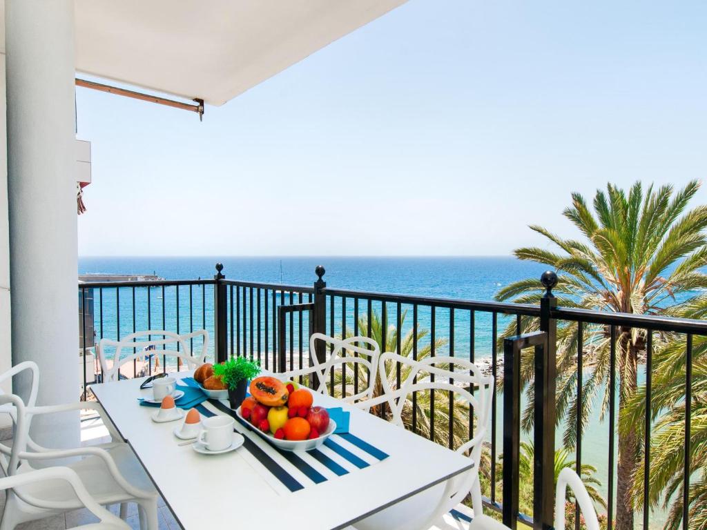 a table with a bowl of fruit on a balcony with the ocean at Beach and View Arguineguin MG by VillaGranCanaria in Arguineguín