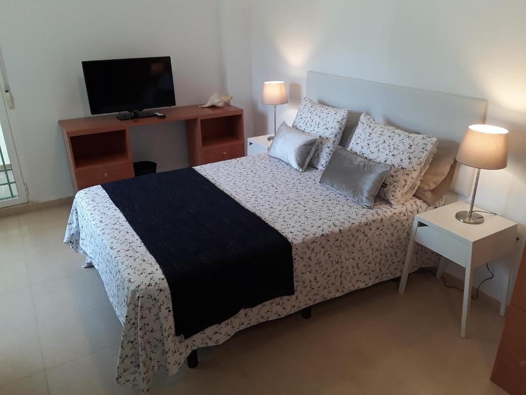 1 dormitorio con 1 cama, TV y mesa en Fan Flat Torremolinos, en Torremolinos