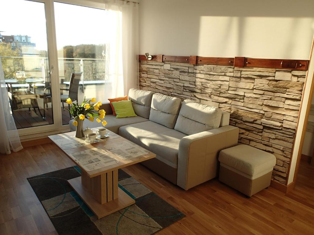 sala de estar con sofá y mesa en Apartament dla Ciebie z tarasem i garazem, en Kołobrzeg