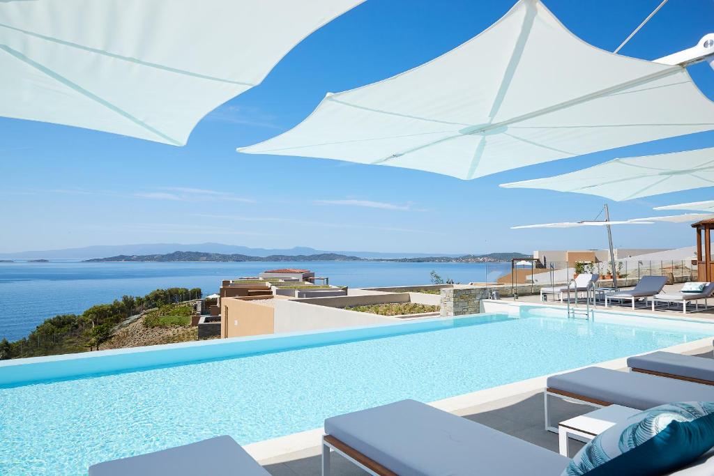 a swimming pool with a view of the water at Eagles Villas - Small Luxury Hotels of The World in Ouranoupoli