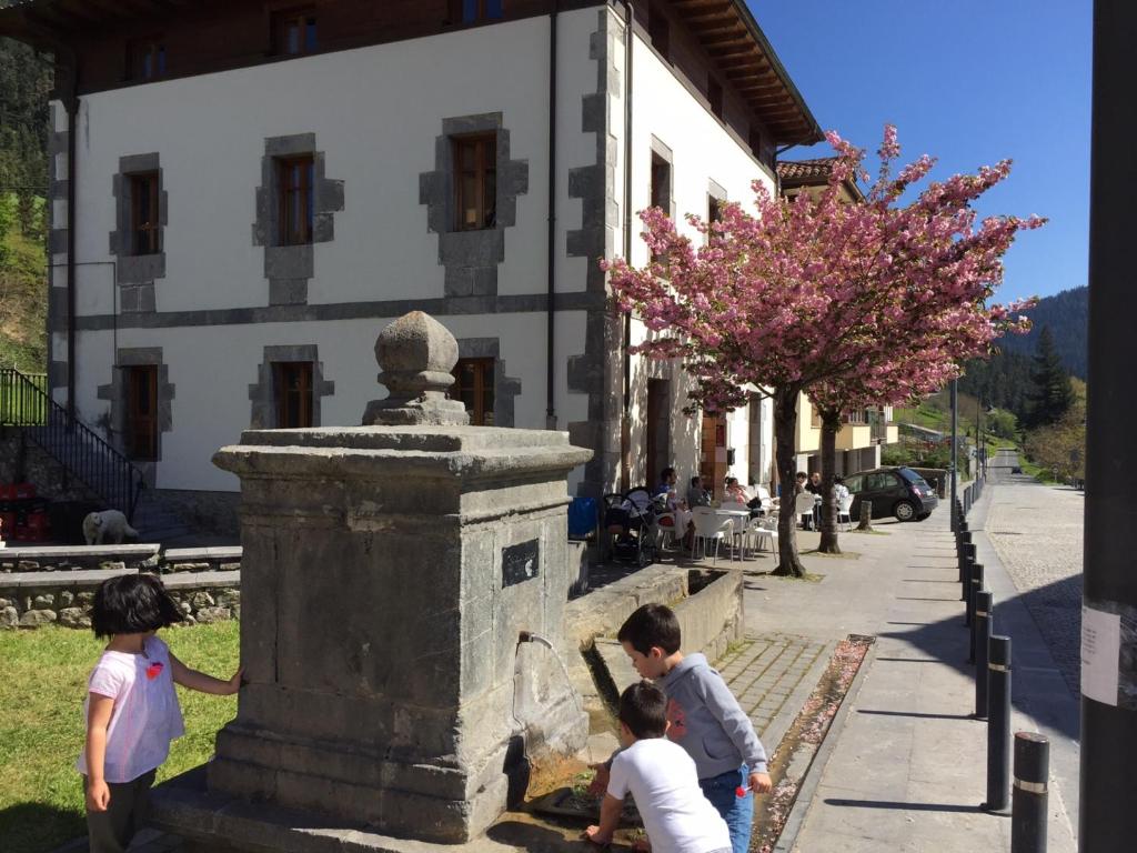 a group of children playing with a fountain on a street at Ubilla Aterpetxea in Aulestia