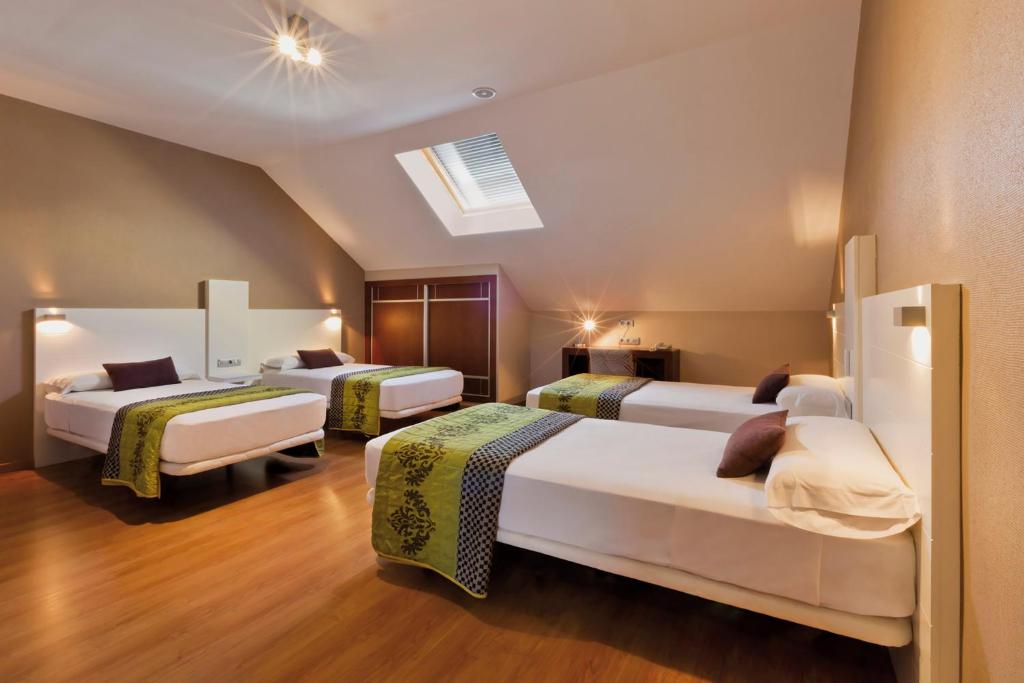 Habitación de hotel con 3 camas y tragaluz en Hotel Fuente El Cura, en Sax