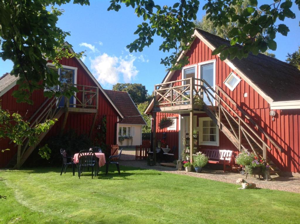 a red house with a table and chairs in the yard at Gånarps rum och Stuguthyrning in Ängelholm