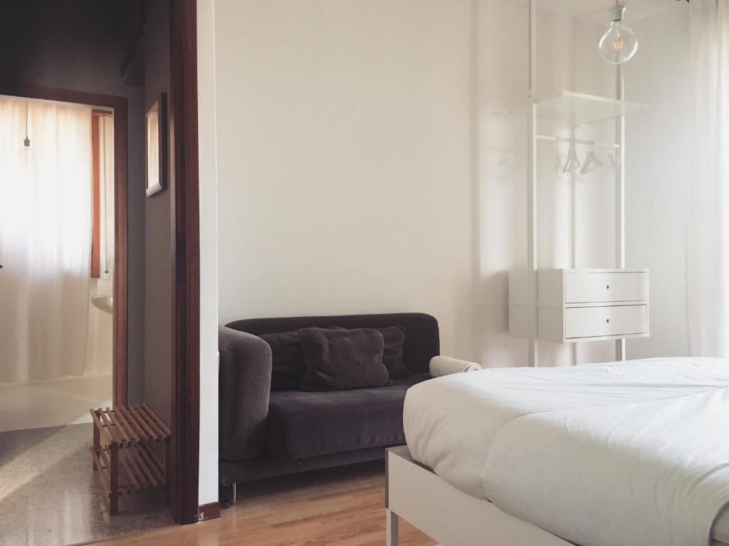 1 dormitorio con 1 cama y 1 sofá en Sunny family apartment in villa - HUMANITAS FORUM IEO, en Pieve Emmanuele
