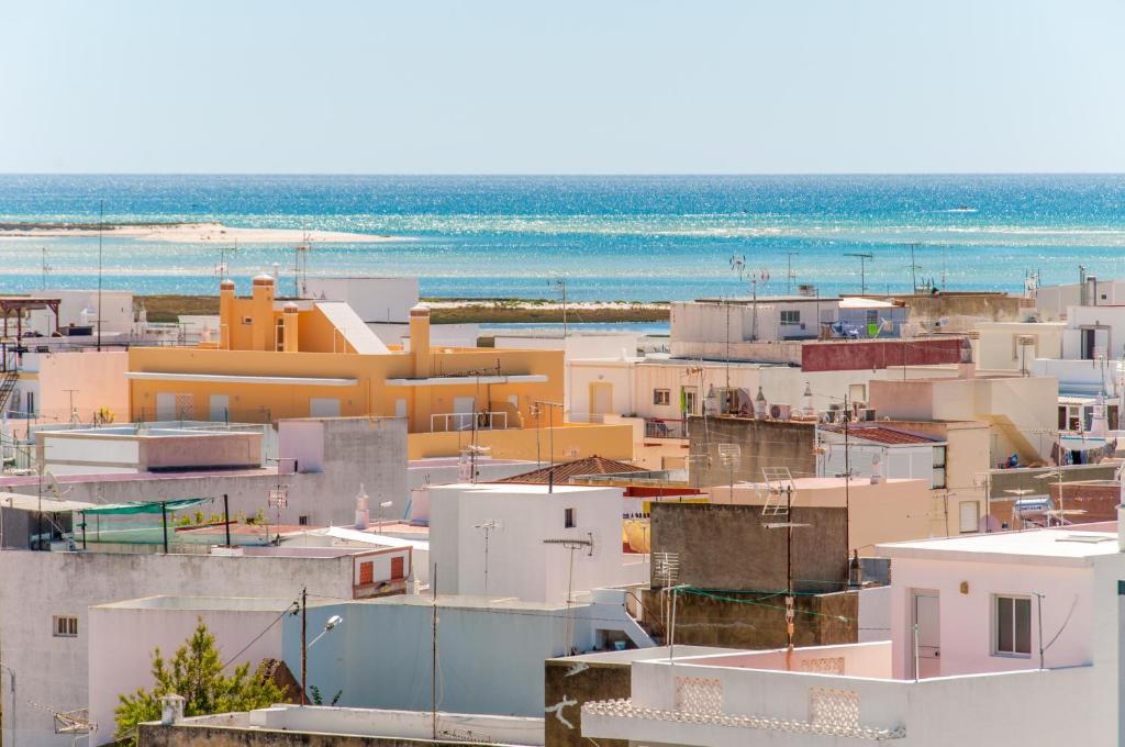 a group of buildings with the ocean in the background at Estudios Salinas - Fuseta in Fuzeta