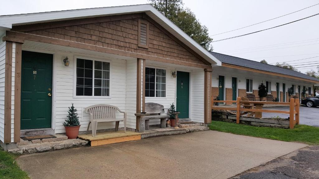a house with a green door and a bench at Bear Cove Inn in Saint Ignace