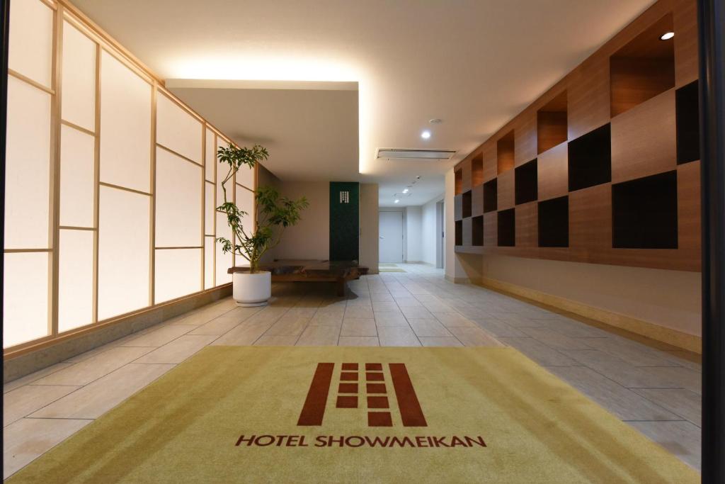 a hallway of a building with a rug on the floor at Hotel Showmeikan in Mishima