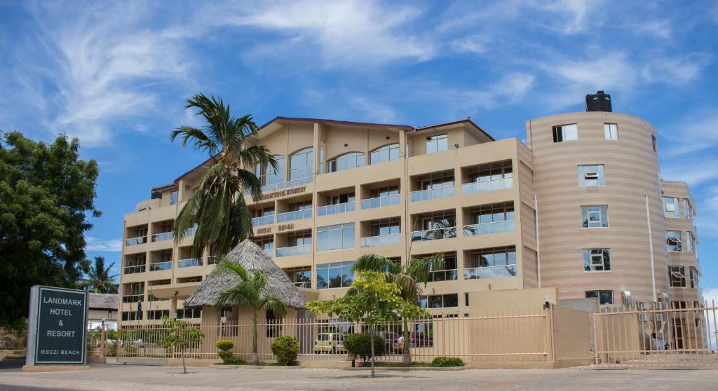 a building with a palm tree in front of it at Landmark Mbezi Beach Resort in Dar es Salaam