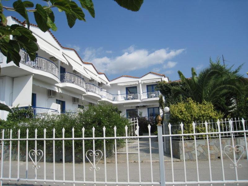 a white fence in front of a building at Leventis Apartments in Rovies