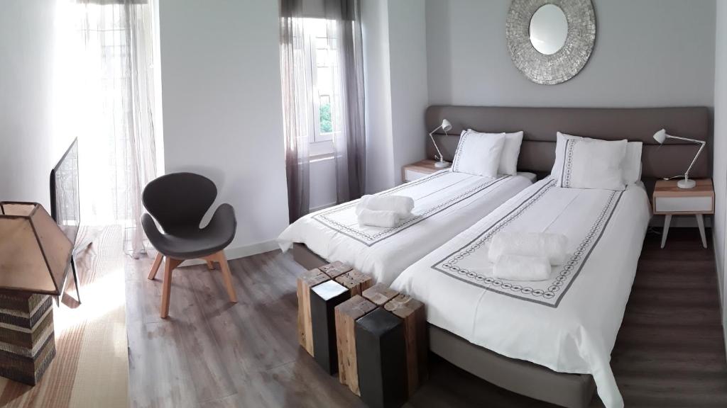 a bedroom with a large white bed and a chair at Shades of Grey - Lisbon in Lisbon