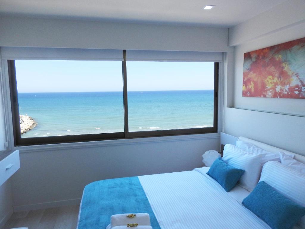 a bedroom with a bed with a view of the ocean at Lazuli Sea View Beachfront Ap 253 in Larnaka