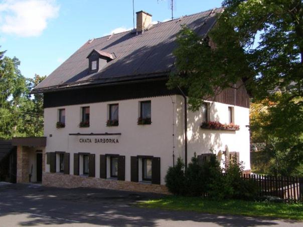 a large white building with a black roof at Chata Barborka in Loučná pod Klínovcem