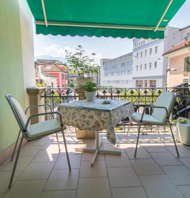 a patio with a table and chairs on a balcony at Hotel Corona in Locarno