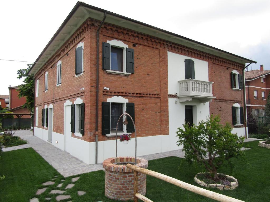 a large brick building with a yard in front of it at Il Batacchio B&B in Minerbio