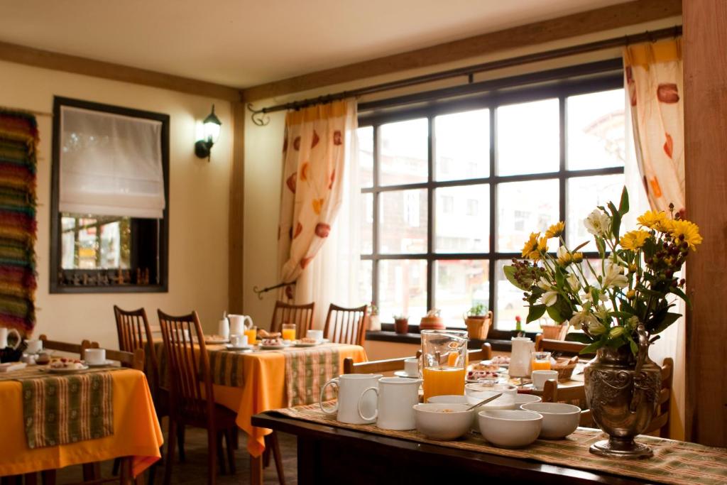 uma sala de jantar com mesas e cadeiras e uma grande janela em Weisserhaus em Puerto Varas