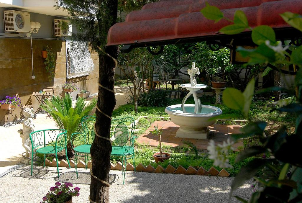 a fountain in the middle of a yard with chairs at B&B Tiburtina Garden in Rome