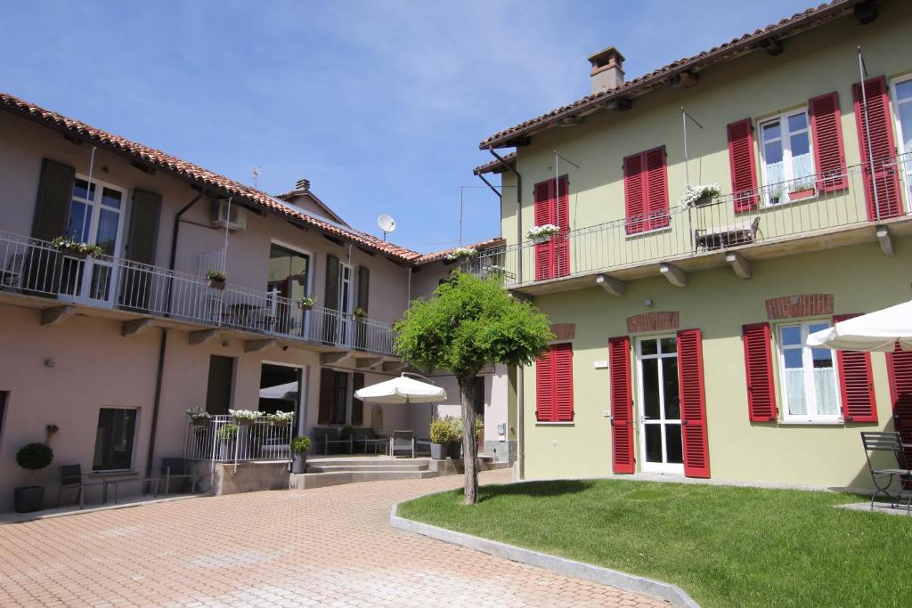 ein Gebäude mit roten Rollläden und einem Innenhof in der Unterkunft Casa Andrea in La Morra