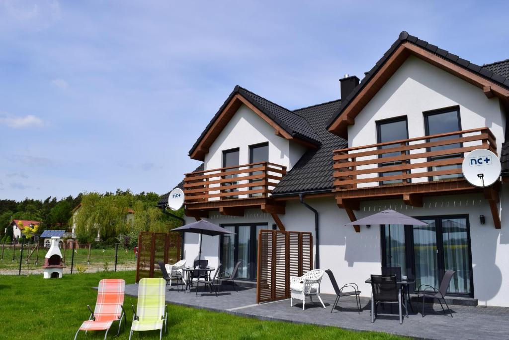 a house with chairs and tables in front of it at Na Fali in Gdańsk