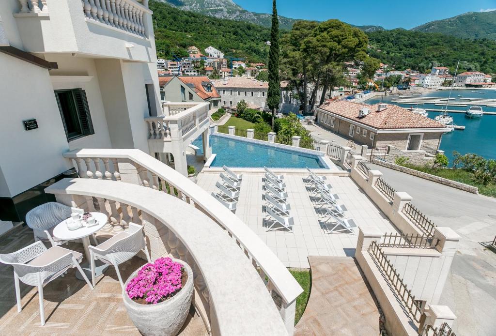 a balcony with a table and chairs and a pool at Boutique Hotel Kredo in Herceg-Novi