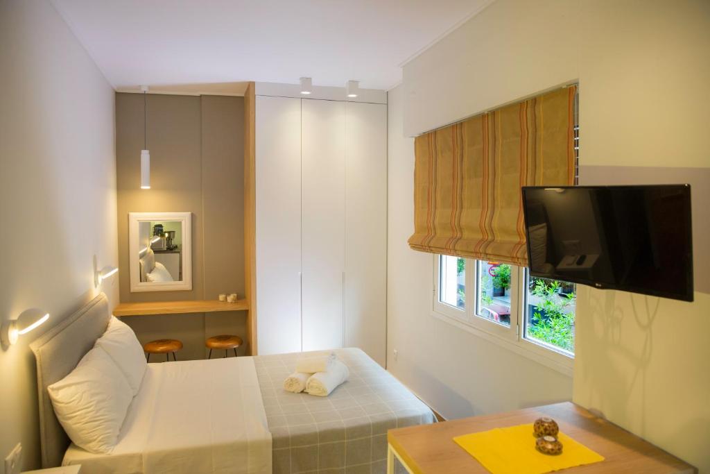 アテネにあるSkoufa Apartmentのベッド1台とテレビが備わる小さな客室です。