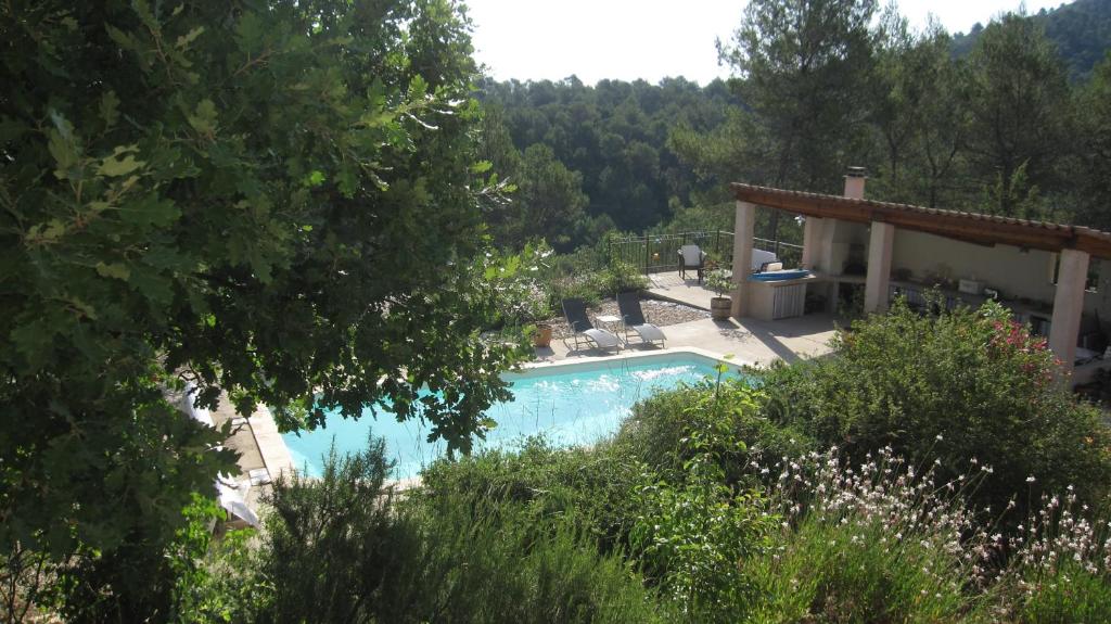 a swimming pool in front of a house at Les Hauts des Materonnes in Tourves