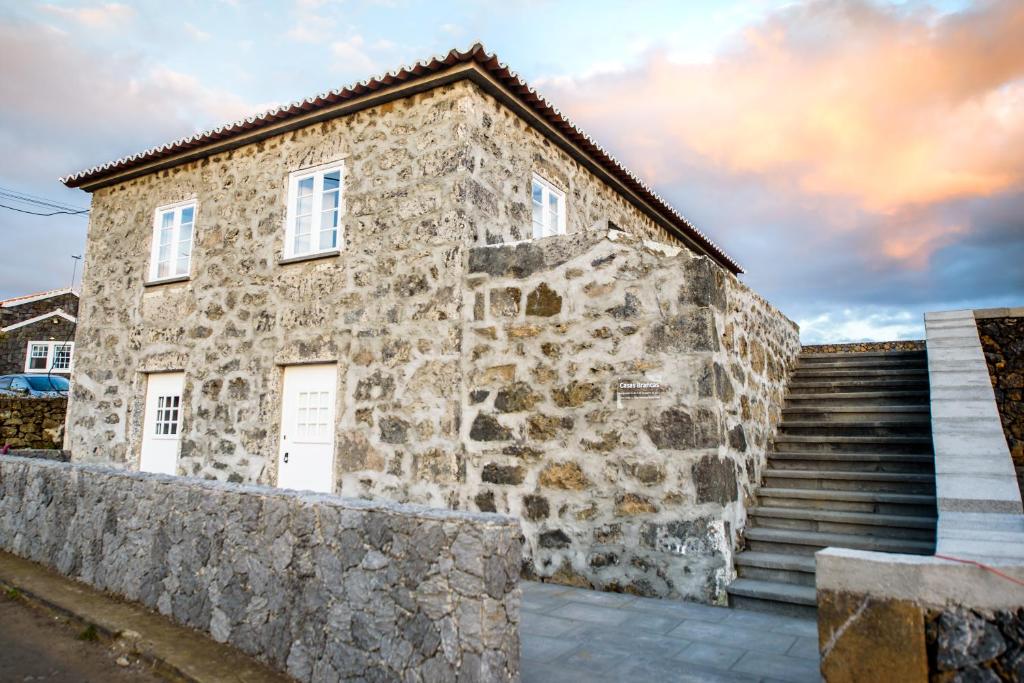 ein Steingebäude mit einer Treppe neben einer Steinmauer in der Unterkunft Casa Branca da Sociedade in Angra do Heroísmo