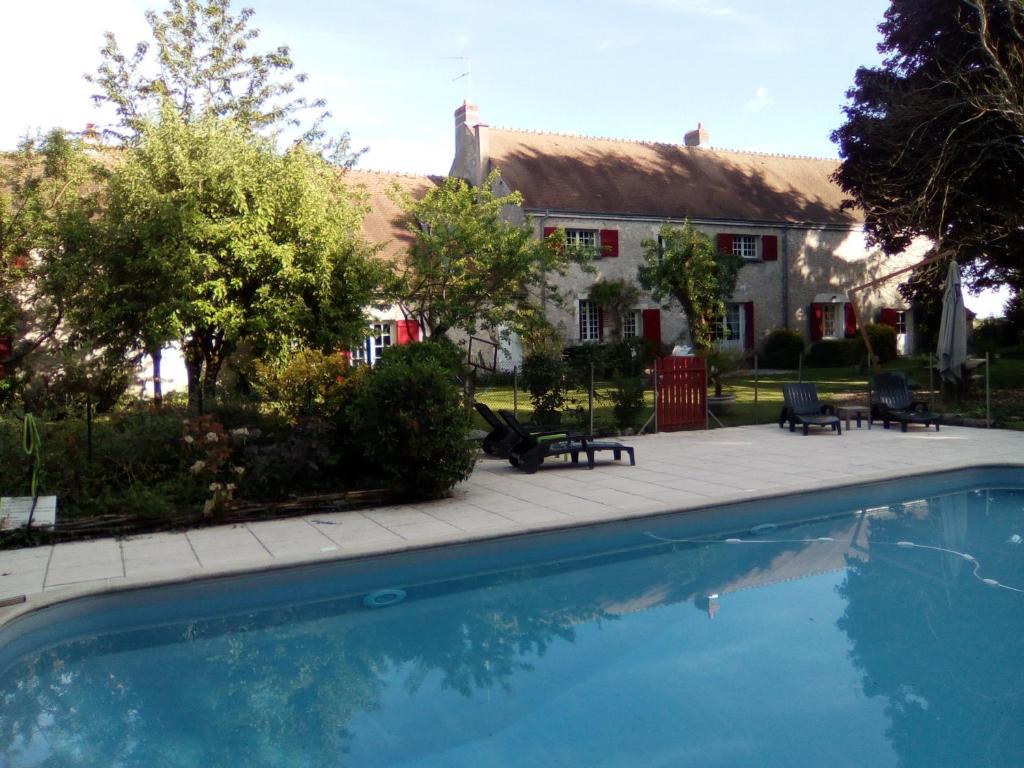 a swimming pool in front of a house at Le Clos de la Vigneronne in Messas