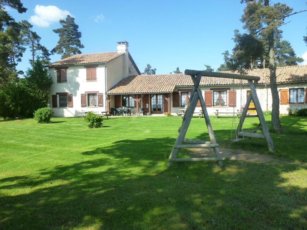 un columpio en un patio frente a una casa en Auberge les Volpilières, en Ruynes-en-Margeride