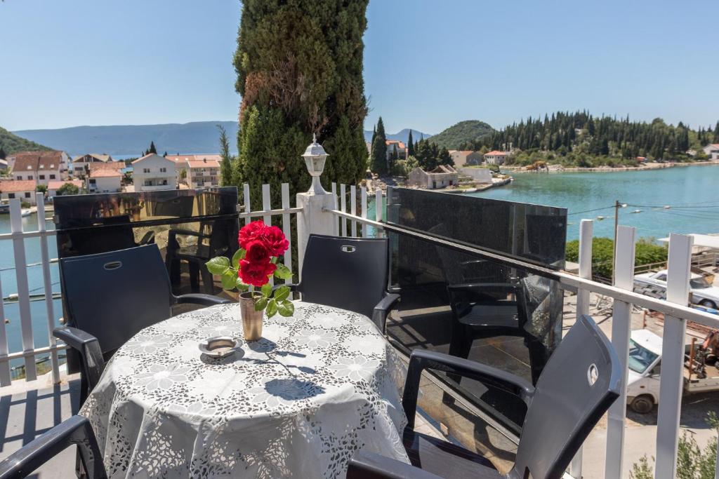 a table with a vase of flowers on a balcony at Apartments Laura in Blace