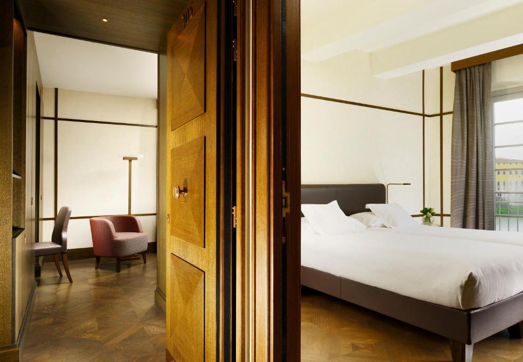 a hotel room with a bed and a chair at Hotel Balestri - WTB Hotels in Florence