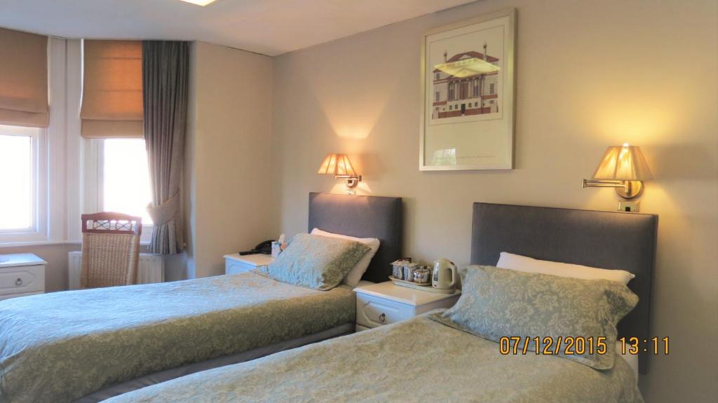 a bedroom with two beds and two lamps at Hunters Lodge Guest House in Southampton