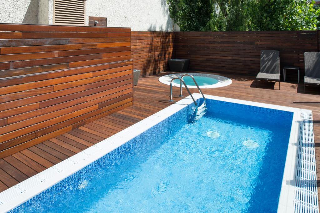 a swimming pool with a wooden fence next to a swimming pool at Catalonia Mikado in Barcelona