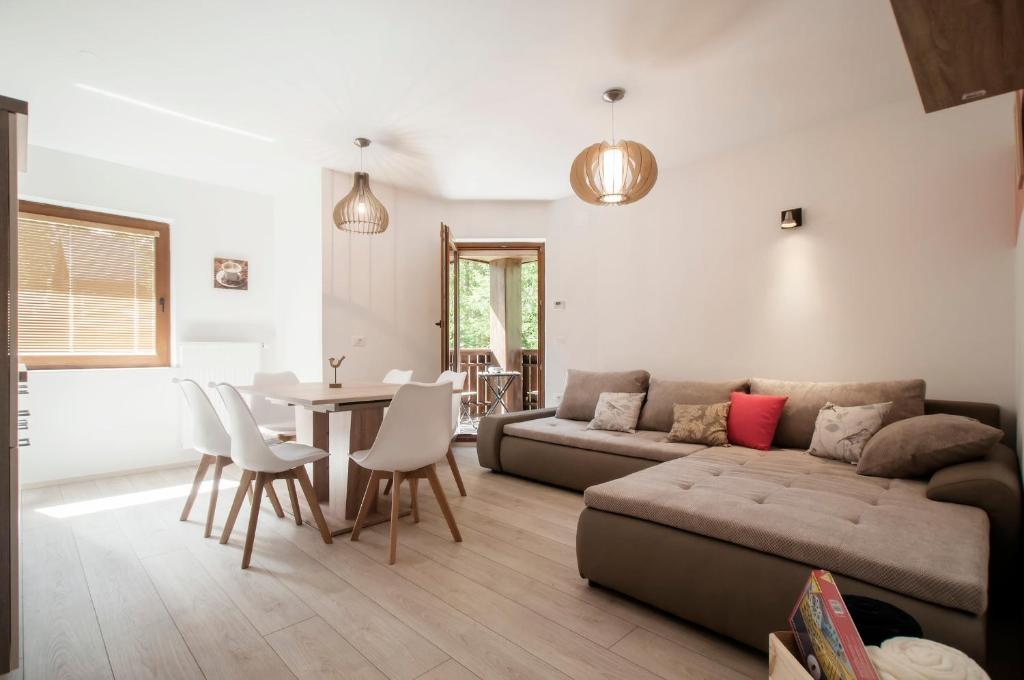 uma sala de estar com um sofá e uma mesa em Apartments Villa Vesna Pokljuka em Goreljek