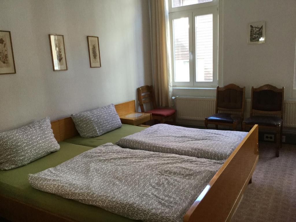 1 dormitorio con 2 camas, sillas y ventana en Haus Jakobi, en Goslar