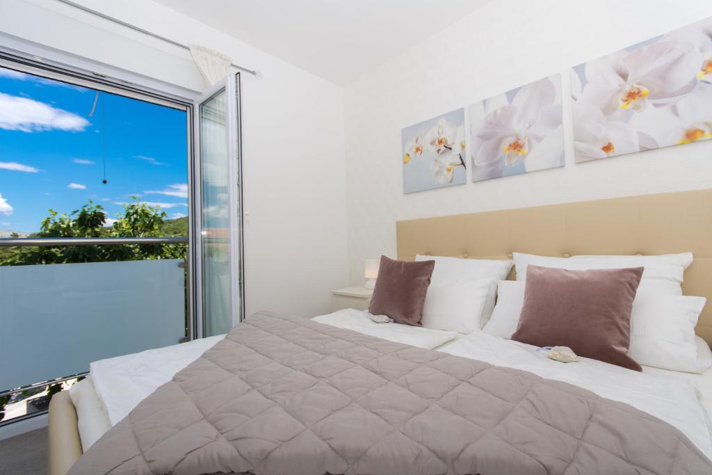 a bedroom with a large bed and a large window at Villa Anastasia in Trogir